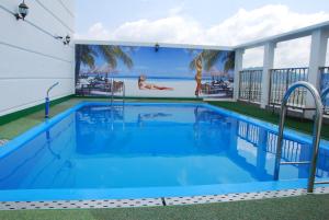 a swimming pool with a mural on the side of a building at Geoje Residence Hotel in Geoje