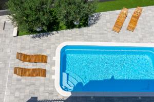 an overhead view of a swimming pool with two chairs at Villa Kalani in Kaštela