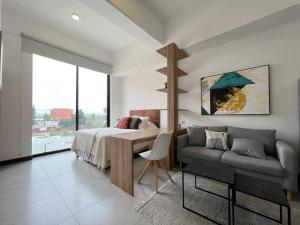 a bedroom with a bed and a couch and a table at Nuevo apartamento cercano al Aeropuerto gran vista in Guatemala