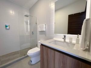 La salle de bains blanche est pourvue de toilettes et d'un lavabo. dans l'établissement Nuevo apartamento cercano al Aeropuerto gran vista, à Guatemala