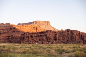a large rock formation in the desert with a mountain at Redrock Riverside Cave 3 - Glamping Cave Suite in Moab