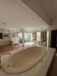 ein großes Zimmer mit einer großen Badewanne in der Mitte in der Unterkunft Puri Mas Boutique Resort & Spa in Senggigi 