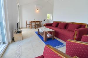 uma sala de estar com um sofá vermelho e uma mesa em Apartment's Belvedere em Kotor