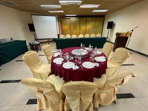 un tavolo in una stanza con sedie e un tavolo rosso di Oriental Crystal Hotel a Kajang