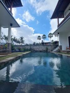a swimming pool in front of a house at Villa Kemuning in Tegalalang