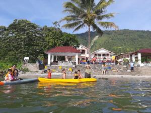 a group of people in canoes in the water at Hotel Barbara in Tuktuk Siadong