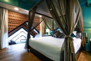 a bedroom with a bed with a canopy at The Moment Chiangmai in Chiang Mai