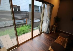 Pokój z balkonem z dużymi przesuwnymi szklanymi drzwiami w obiekcie HIDAKA STAY VILLA 柴又 w Tokio