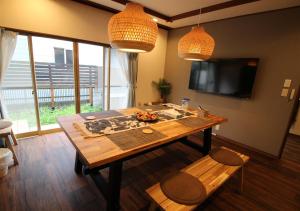 a living room with a wooden table and a television at HIDAKA STAY VILLA 柴又 in Tokyo