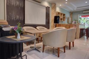 ein Esszimmer mit Tischen, Stühlen und einem Whiteboard in der Unterkunft Super OYO Townhouse Oak Grand Orienchi in Jakarta