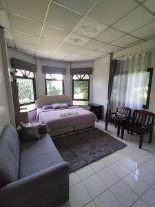 a bedroom with two beds and a couch at Lamphun Garden Home in Lamphun