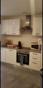 a kitchen with white cabinets and a stove top oven at new private room ,sea view, near airport 5 min, train 3 min and tram on site, beach 7 min, 2 showers and 2 toilets. Neuf , chambre privative, vue mer, proche aéroport 5 min , train 3 min et tramway sur place, plage 7 min, 2 douches et 2 wc. in Nice