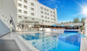 a large swimming pool in front of a hotel at Geneva Hotel in Amman