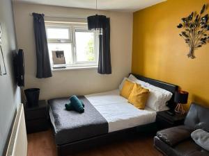 a bed in a room with a couch and a window at New Cross Hospital - 4 Bedrooms, 2 Bathrooms, Free Parking in Wolverhampton