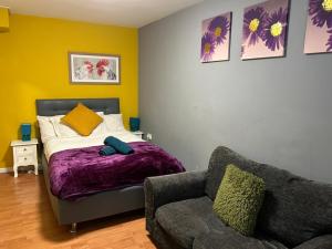 a bedroom with a bed and a couch and a chair at New Cross Hospital - 4 Bedrooms, 2 Bathrooms, Free Parking in Wolverhampton