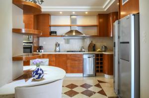 a kitchen with wooden cabinets and a vase of flowers on a table at Netanya Panoramic Sea-View Apt by Sea N' Rent in Netanya