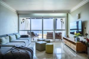 a living room with a couch and a view of the ocean at Netanya Panoramic Sea-View Apt by Sea N' Rent in Netanya