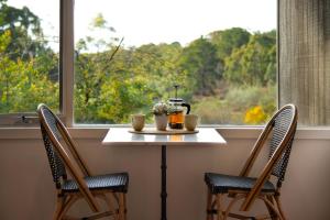 a table with two chairs in front of a window at Daylesford Spa Villa 4 in Daylesford