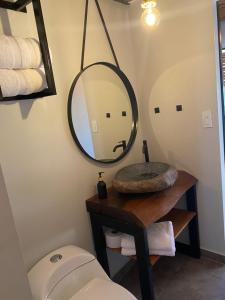 a bathroom with a sink and a mirror and a toilet at Glamping Las Rocas in Calima