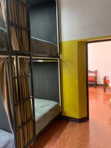 a room with a bunk bed and a doorway at One Day Trip Hostel in Antigua Guatemala