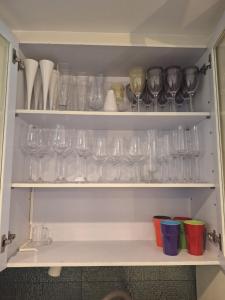 a cupboard filled with lots of glasses and bowls at Pool Villa 3bedroom Bann Anda by fantaseabeachpattaya in Nong Prue