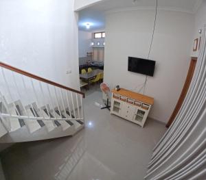 ein Wohnzimmer mit einer Treppe und einem TV in der Unterkunft Damai Residence Homestay Jogja in Ngaglik