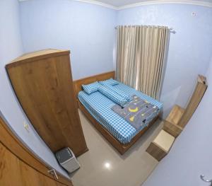 ein kleines Schlafzimmer mit einem Bett und einem Vorhang in der Unterkunft Damai Residence Homestay Jogja in Ngaglik