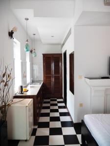 a kitchen with a black and white checkered floor at The Bygone in Siem Reap