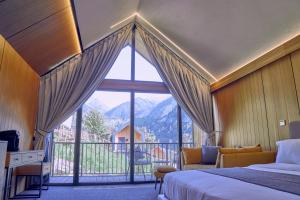 1 dormitorio con cama y ventana grande en Qazaq Auyl Eco Hotel en Almaty
