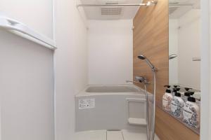 a shower in a bathroom with white walls at LEGALAND Gakushuin Shita in Tokyo +16 photos
