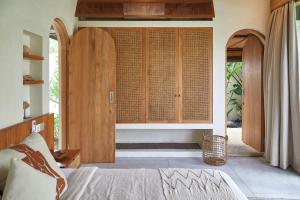 a bedroom with a bed and a large window at Villa Cerah in Uluwatu