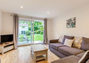 sala de estar con sofá y TV en Amazing Home In Newquay With Indoor Swimming Pool, Wifi And Heated Swimming Pool, en Newquay