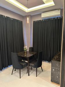 uma sala de jantar com uma mesa e cortinas pretas em The Signature Hotel em Islamabad