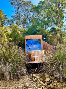 a mirror sitting on top of a hill with grass at Wingtons Glamping in Clarence Point