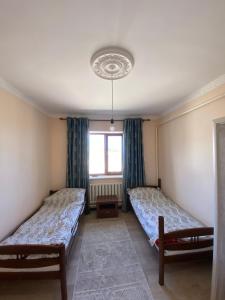 a room with two beds and a window at Maksat house in Tossor
