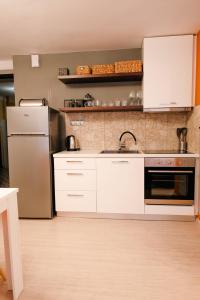a kitchen with white cabinets and a stainless steel refrigerator at Venizelou Comfort & Living I in Kavala