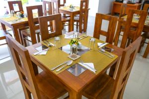 a wooden table with utensils on it in a restaurant at Citrus Cafe & Restaurant in Kandy