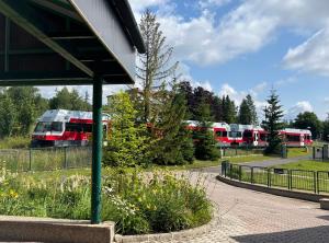dos autobuses están estacionados en un estacionamiento en Penzión na vyhliadke en Vysoke Tatry - Horny Smokovec