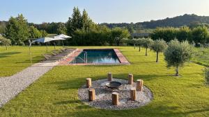 un jardín con piscina y hoguera en CA`NOVA AGRITURISMO, en Castellaro
