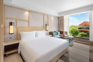 a bedroom with a large white bed and a large window at The Westin Goa in Vagator