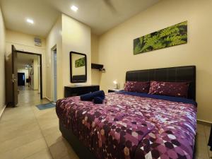 a bedroom with a large bed with a purple comforter at Fathers Guesthouse Age 7 years old and above only in Tanah Rata