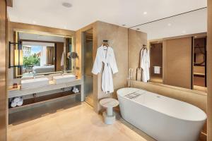 a bathroom with a large tub and two sinks at The Westin Goa in Vagator