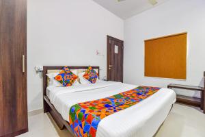 a bedroom with a large bed with a colorful blanket at Hotel Vandana Palace in Kota