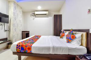 a bedroom with a bed with a colorful blanket at Hotel Vandana Palace in Kota