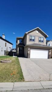 a large house with a garage on a street at Spacious comfortable Air-Conditioned. Near airport! in Calgary