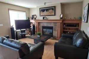 sala de estar con sofá y chimenea en Spacious comfortable Air-Conditioned. Near airport! en Calgary