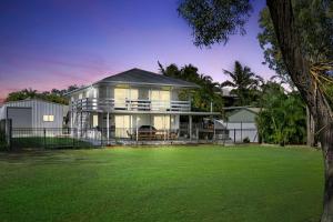 ein großes Haus mit Rasen davor in der Unterkunft Casa Del Mare - 3 Bedroom Home in Burrum Heads