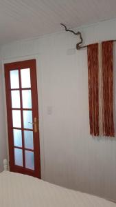 a bedroom with a bed and a door and a window at Cabaña y Hospedaje Rural La Familia in Dalcahue