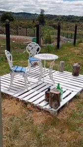 une table et des chaises assises sur une plate-forme en bois avec une table et une table dans l'établissement Cabaña y Hospedaje Rural La Familia, à Dalcahue