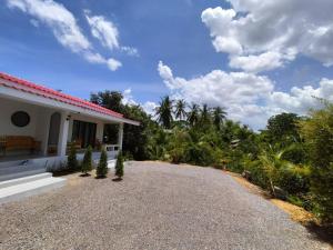 a driveway leading to a house with palm trees at Min House in Lamphun